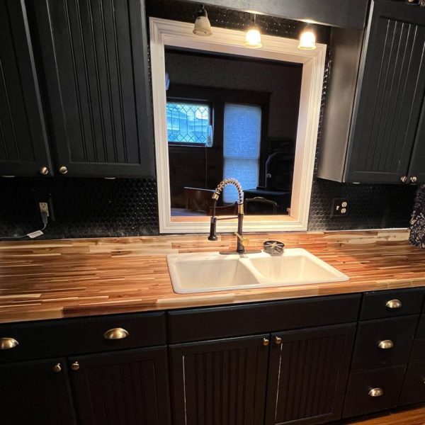 Kitchen remodel with wood countertop, dark cabinets, and a deep set farmhouse sink.